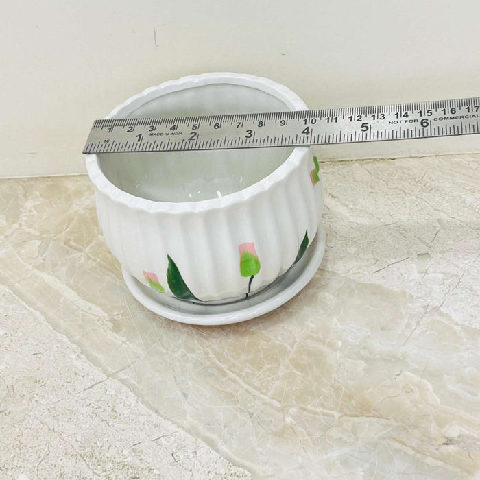 Decorative white ceramic planter with floral accents