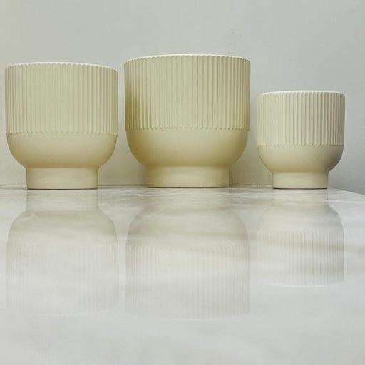 Set of three beige ribbed ceramic planters with flared base