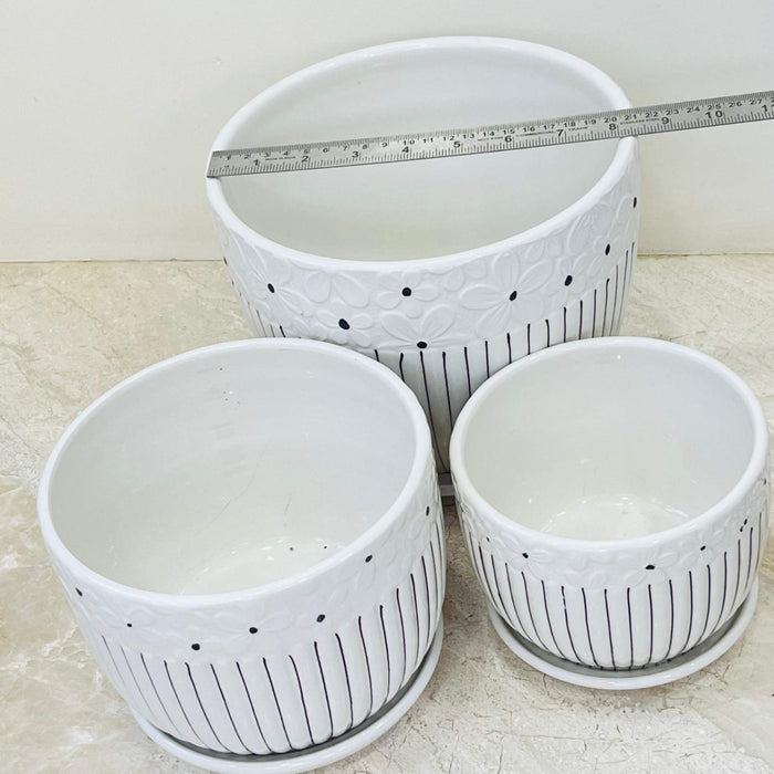 Set of ceramic pots with floral detailing and vertical lines