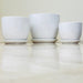 Set of white ceramic pots with matching saucers