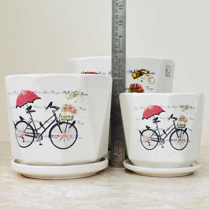 Three ceramic planters with illustrated bicycle pattern