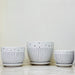 Trio of elegant ceramic pots with floral texture and stripe accents