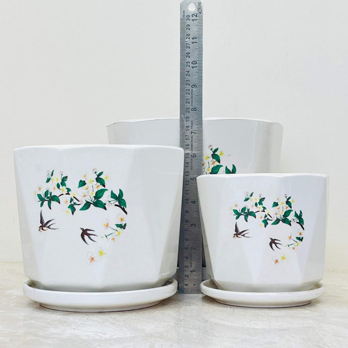 Set of white ceramic pots featuring bird and floral motif