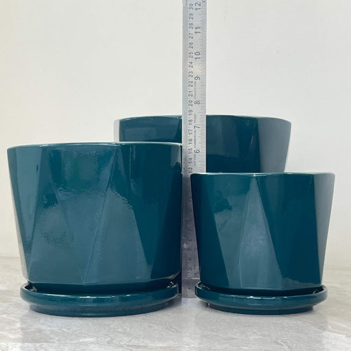 Glossy faceted ceramic plant pots in teal color