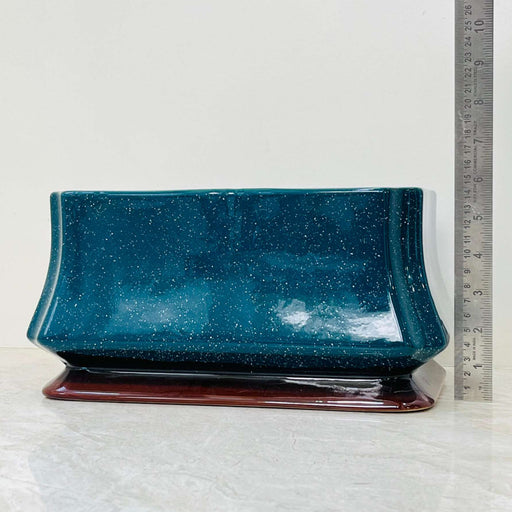 Glossy teal ceramic planter with brown base