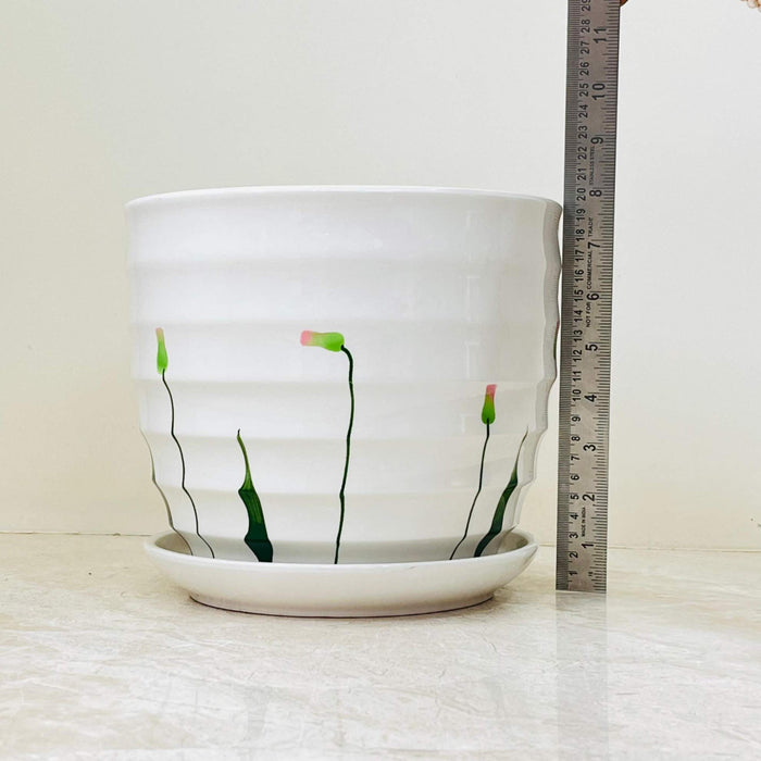 Three white ceramic pots with floral patterns and ribbed texture