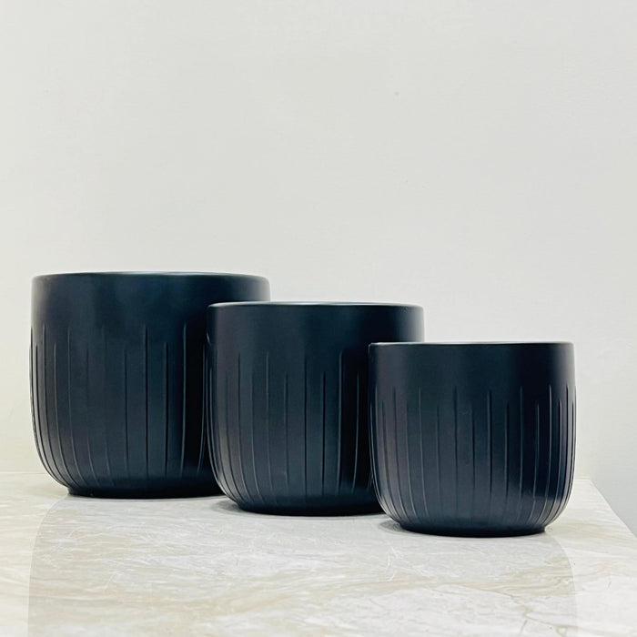 Medium matte black plant pot with vertical texture