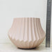 Textured beige ceramic plant pot with vertical ridges