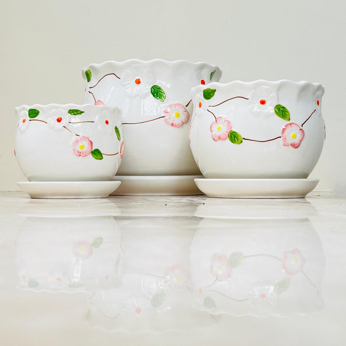 White ceramic pots with pink floral design and scalloped rims