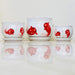 White ceramic pots with red fish design and scalloped rims