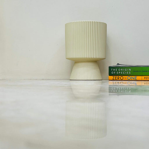 Sleek beige ceramic pot with ribbed texture