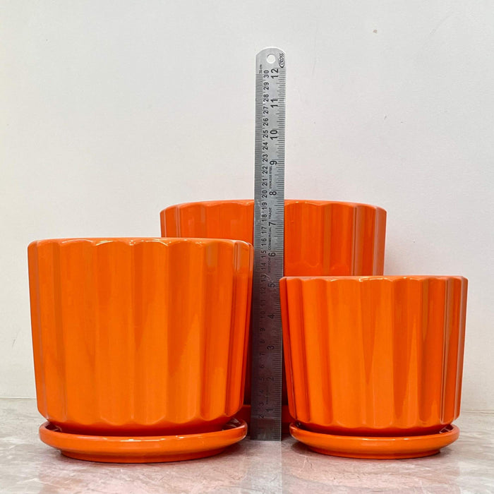 Bright orange ceramic plant pots with ribbed design