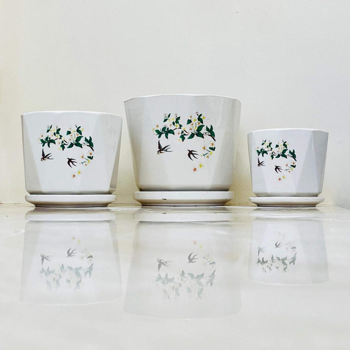 White ceramic planters with floral vine and bird design in three sizes