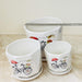 White ceramic pot set featuring bicycle and flower motif