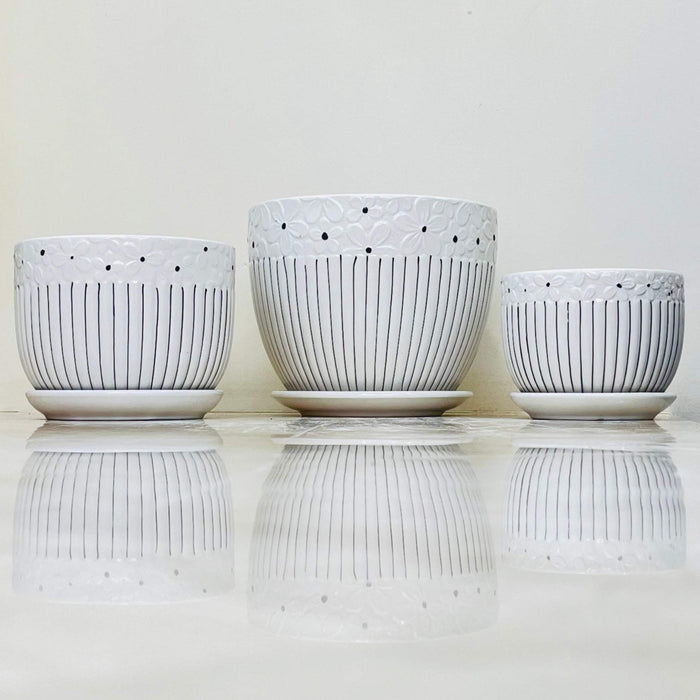 White ceramic pots with embossed floral top and vertical stripes