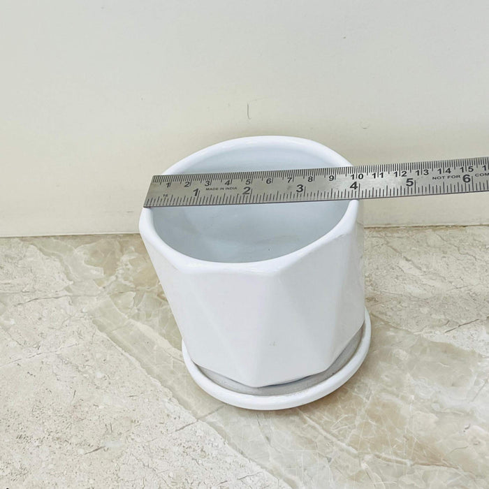 Minimalist white ceramic plant pot with faceted design and matching plate.